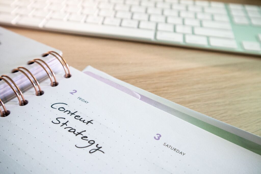 Content strategy written in planner with keyboard on wooden desk